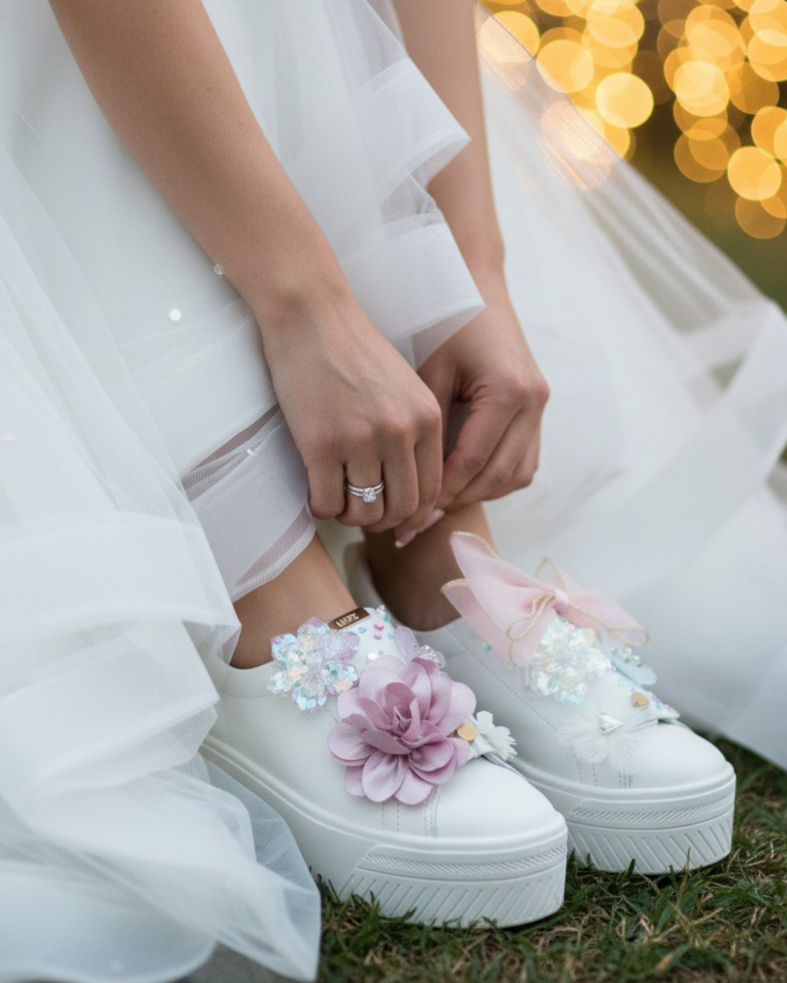 Bride adjusting white lace up shoe styled with LŪPZ Candy shoe accessories.