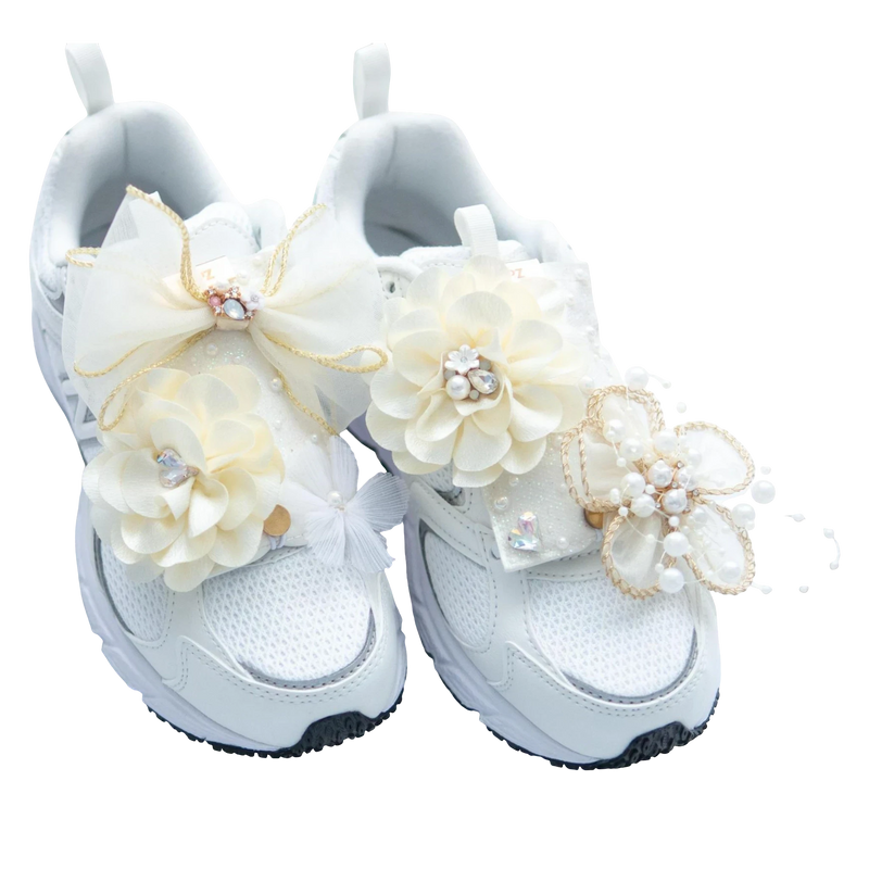 LŪPZ white mesh sneakers adorned with cream fabric flowers, pearls, and bows. Perfect for celebrations.